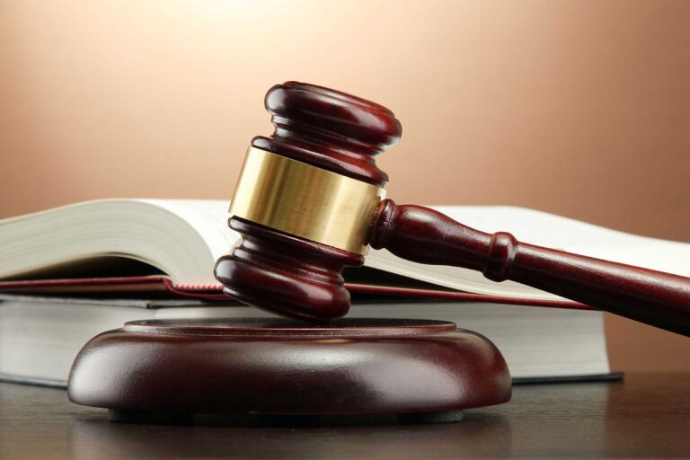 wooden gavel and books on wooden table,on brown background